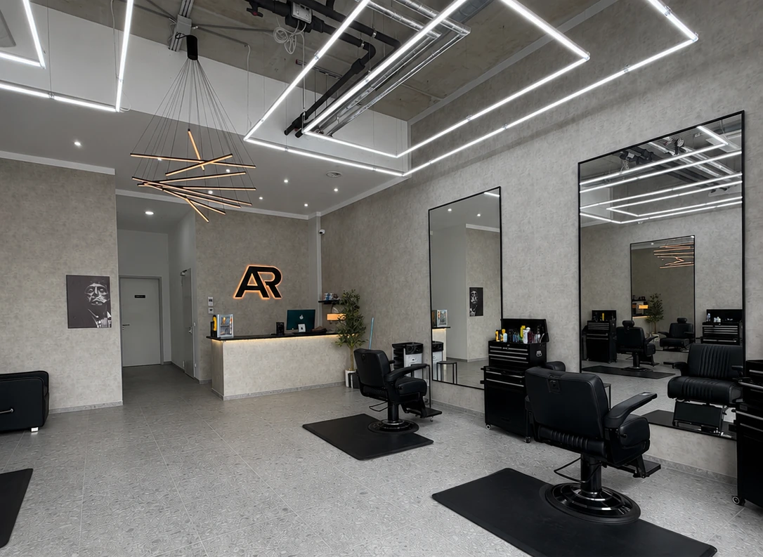 BARBER AR Studio in Berlin Mitte, Empfang mit AR Logo und Barber-Stühlen